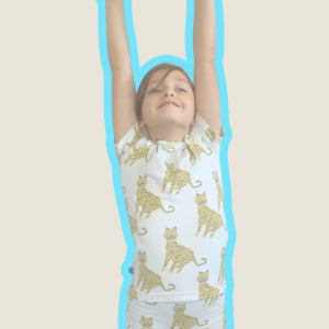Image de notre ensemble Chiche : Une fillette joyeuse portant un ensemble boxer et t-shirt manches courtes pour filles au motif léopard sur fond écran et un boxer assorti.